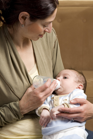Madre che allatta il neonato con il biberon.